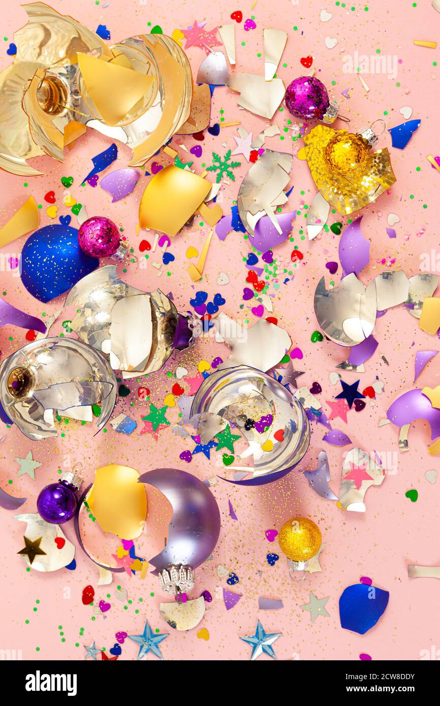 Colorful broken glass Christmas  baubles and glitter on pink Stock Photo