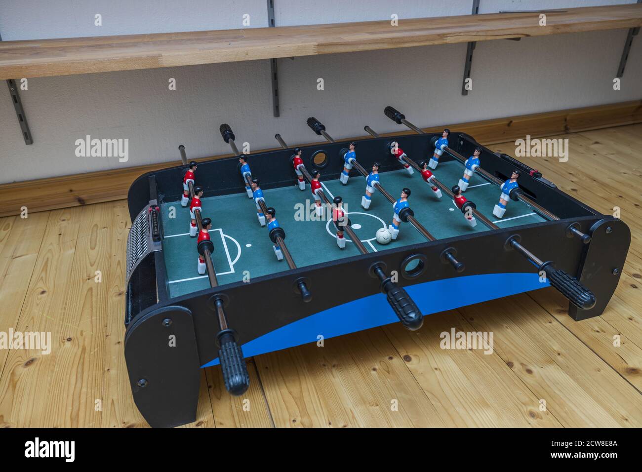 Close up view of old table football game on wooden floor. Home games concept. Stock Photo