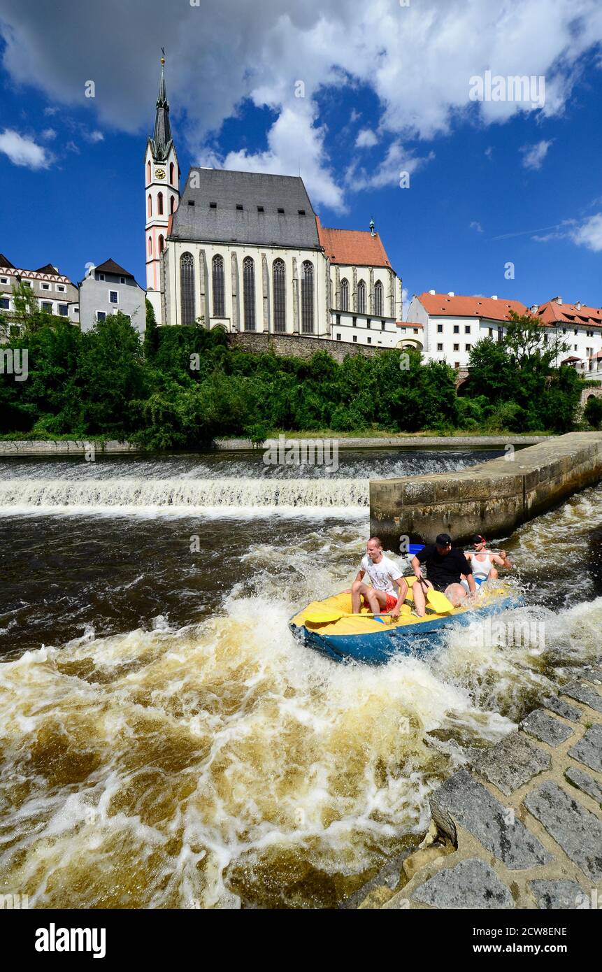 Cesky Krumlov, Czechia - August 11th 2013: Unidentified people in rubber raft on Moldau (Vlatava) river with church of Saint Vitus in the Unesco World Stock Photo