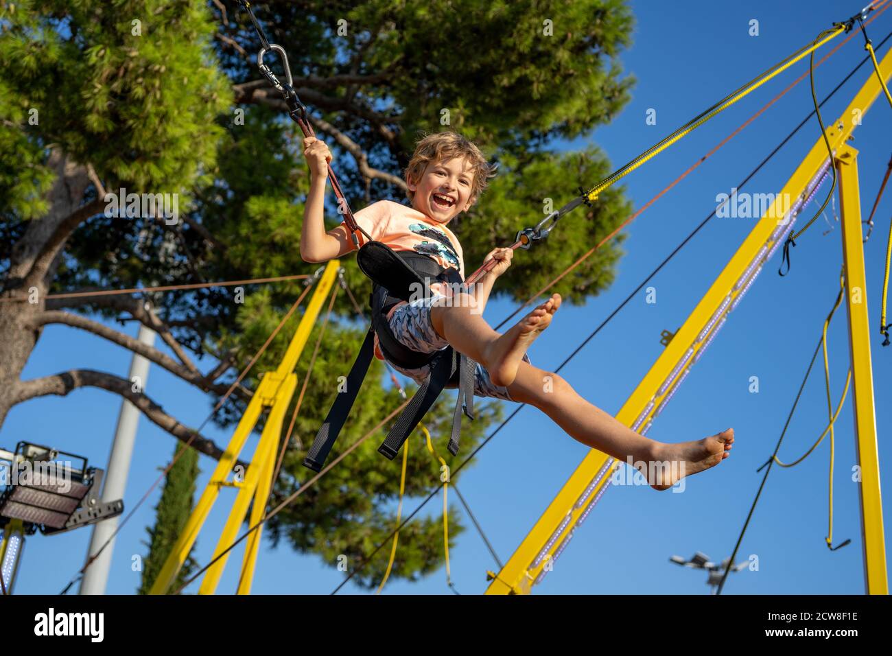 Children have fun jumping on bungee trampoline secured with rubber bands  Stock Photo - Alamy