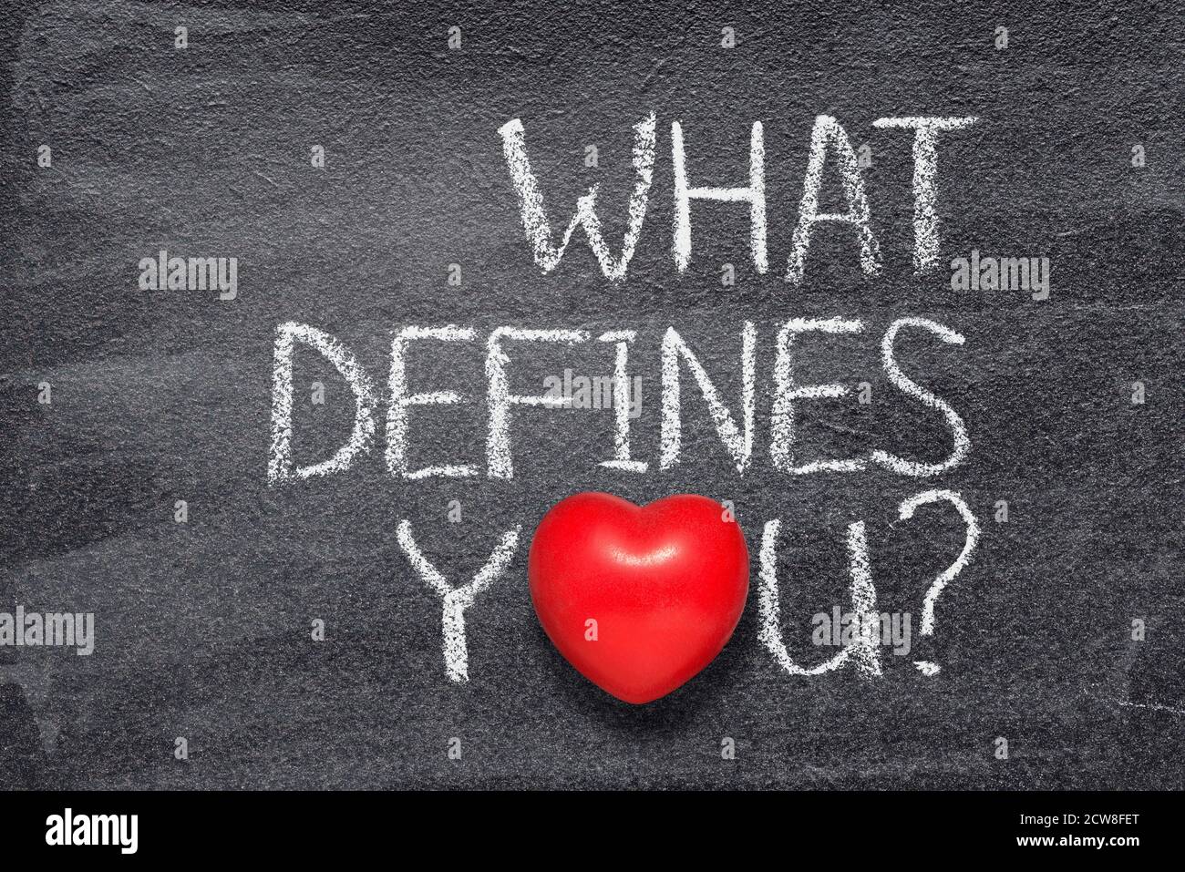 what defines you question written on chalkboard with red heart symbol Stock Photo