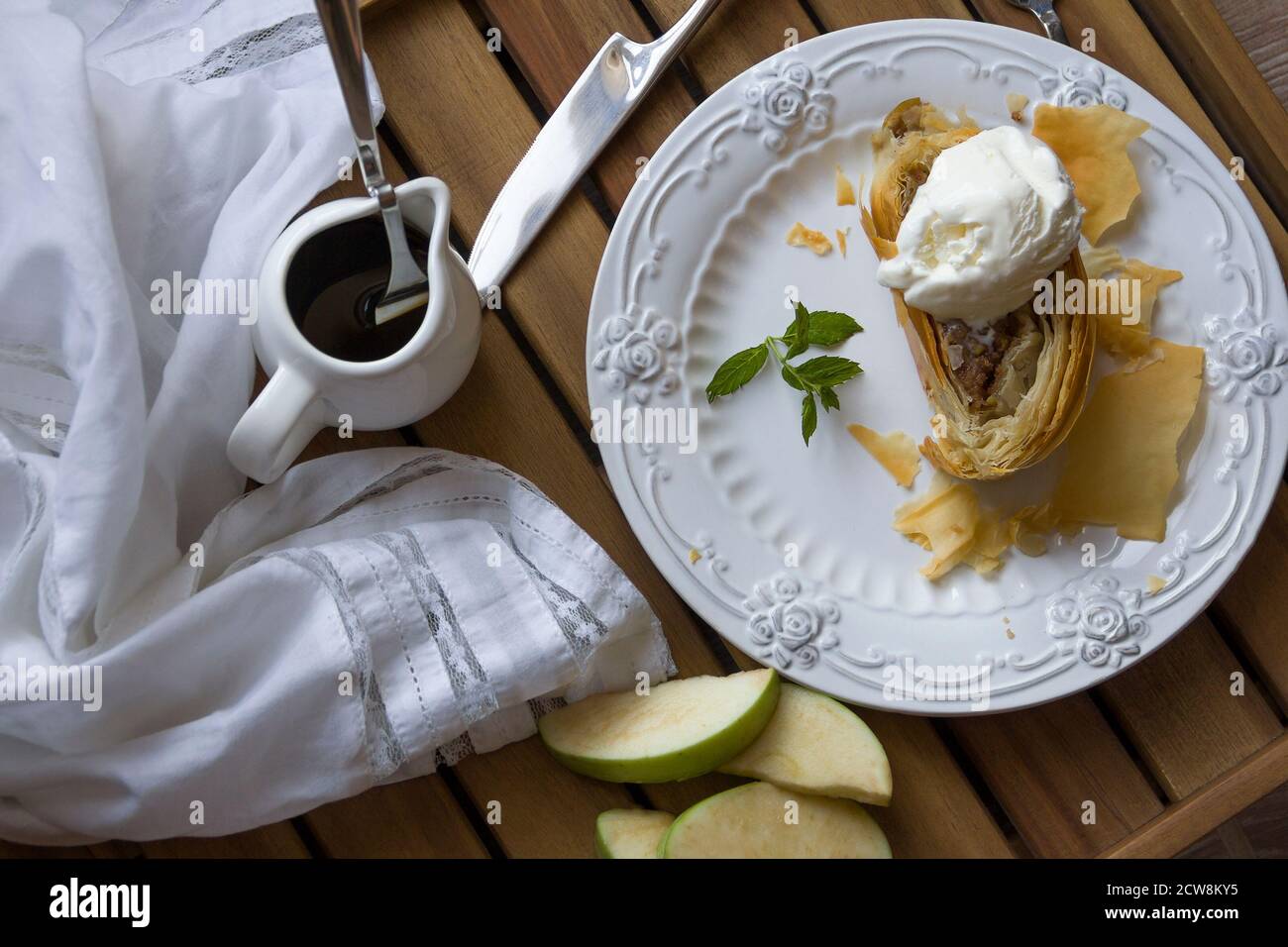 apple strudel with a scoop of vanilla ice cream, mint on a white glass plate. Stock Photo
