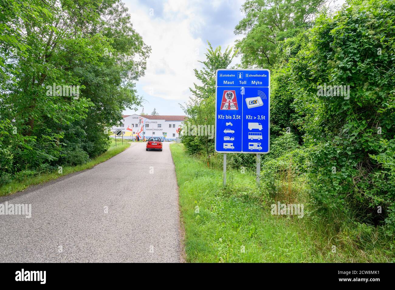 ANGERN AN DER MARCH, AUSTRIA – JULY 21 2020: Big blue board with information about Toll Sticker and Digital Vignette device on entrance road to town A Stock Photo