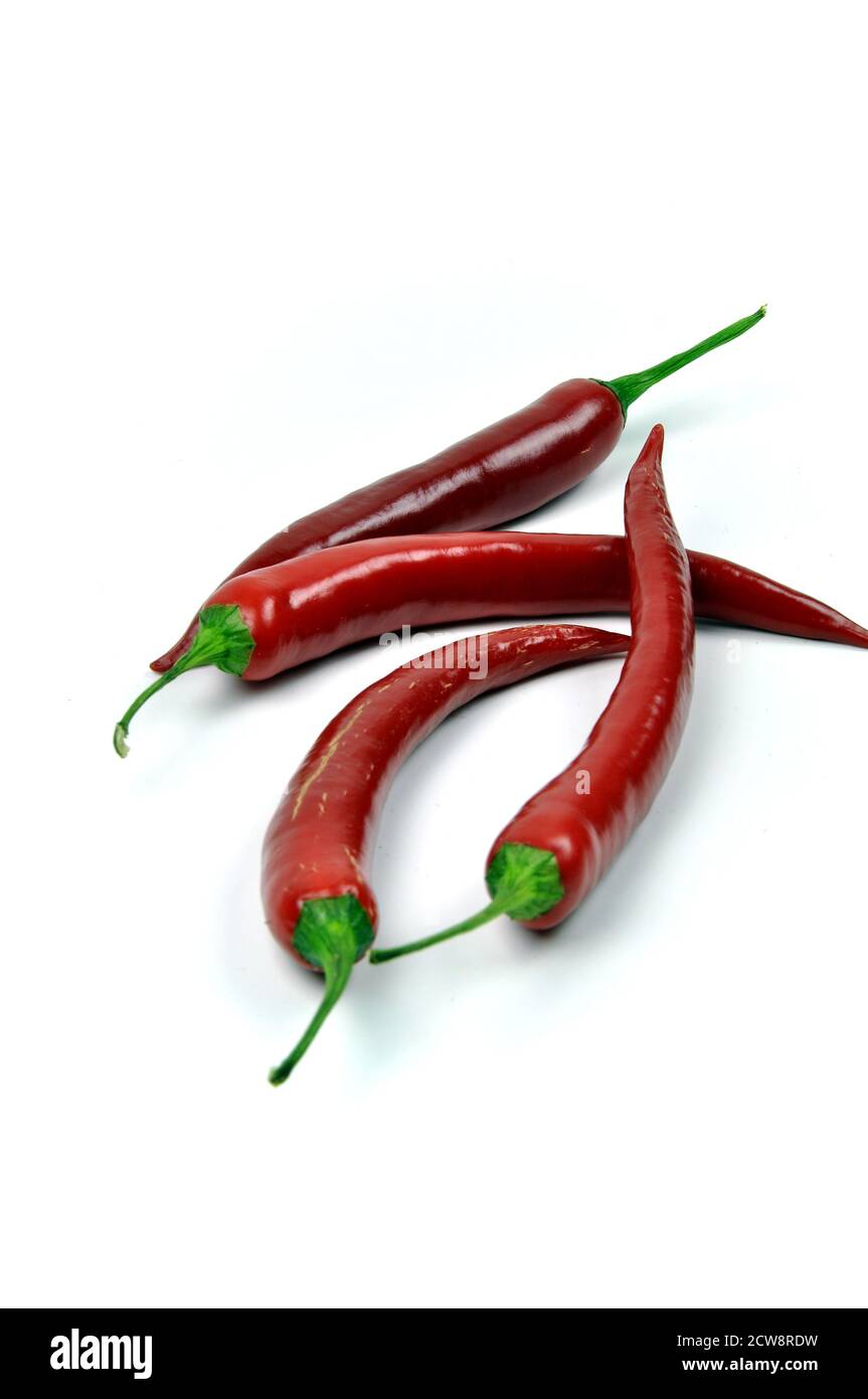 Four red chili peppers isolated on white background Stock Photo - Alamy