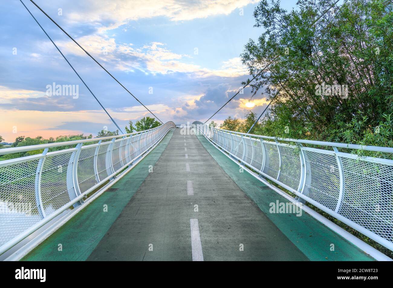 Empty bicycle bridge (called “Freedom bridge”) connecting two countries Slovakia and Austria during sunset (Bratislava, SLOVAKIA) Stock Photo