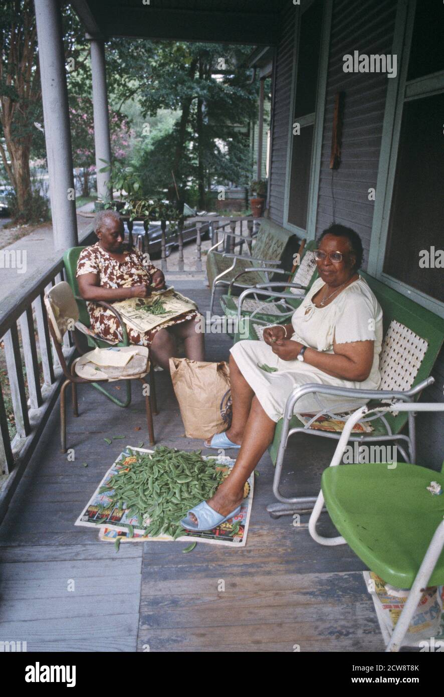 AFRICAN AMERICAN FAMILY SHELLING PEAS IN PORCH IN DOWNTOWN SAVANNAH, GEORGIA, USA,1980s Stock Photo
