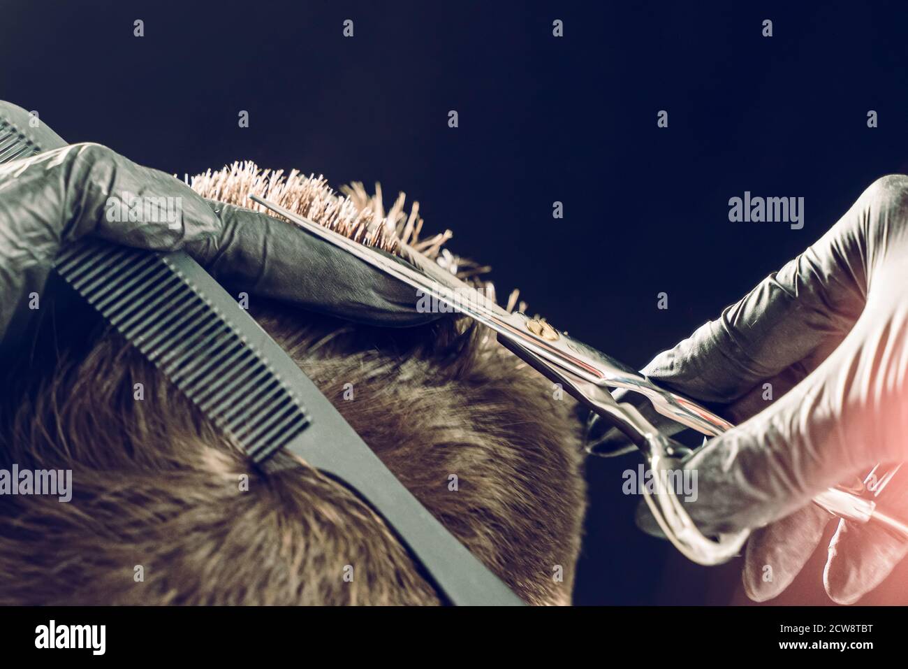 Cropped shot of barber cutting hair of customer with scissors Stock Photo