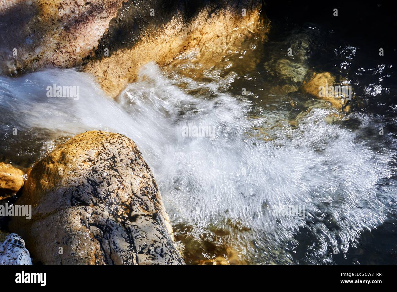 fast clean seething mountain stream among rocks blurred in motion Stock Photo