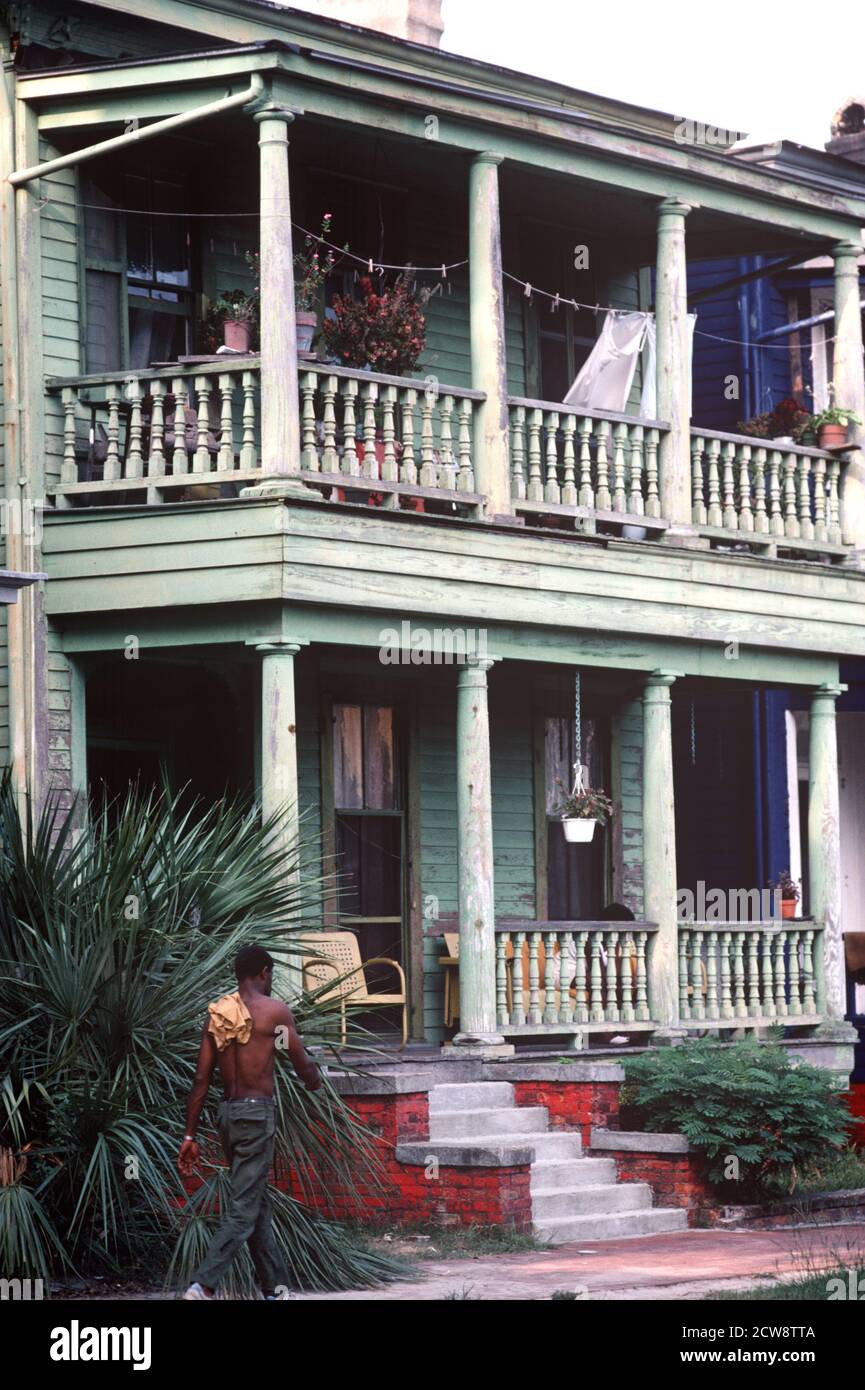 AFRICAN AMERICAN WALKING PAST WOODEN CLAPBOARD HOUSES IN DOWNTOWN SAVANNAH, GEORGIA, USA, 1980s Stock Photo