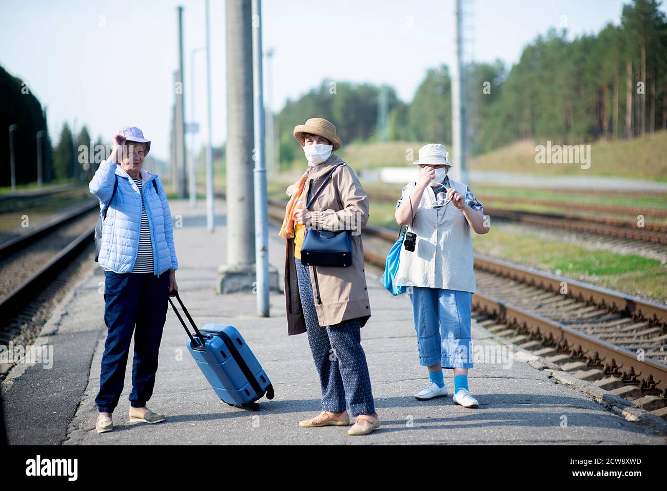 three old senior elderly women on the platform waiting for train and ...