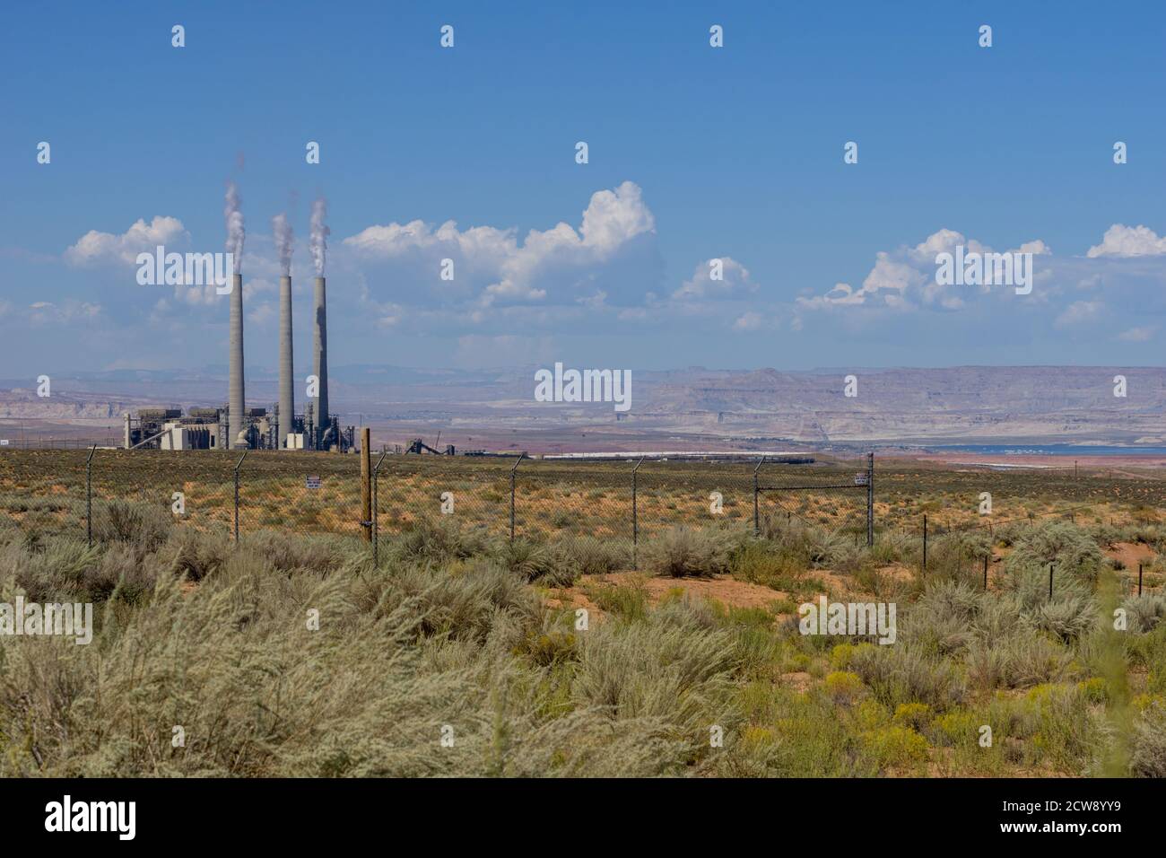 Industrial factory with three tall smoke stacks in flat plains and ...