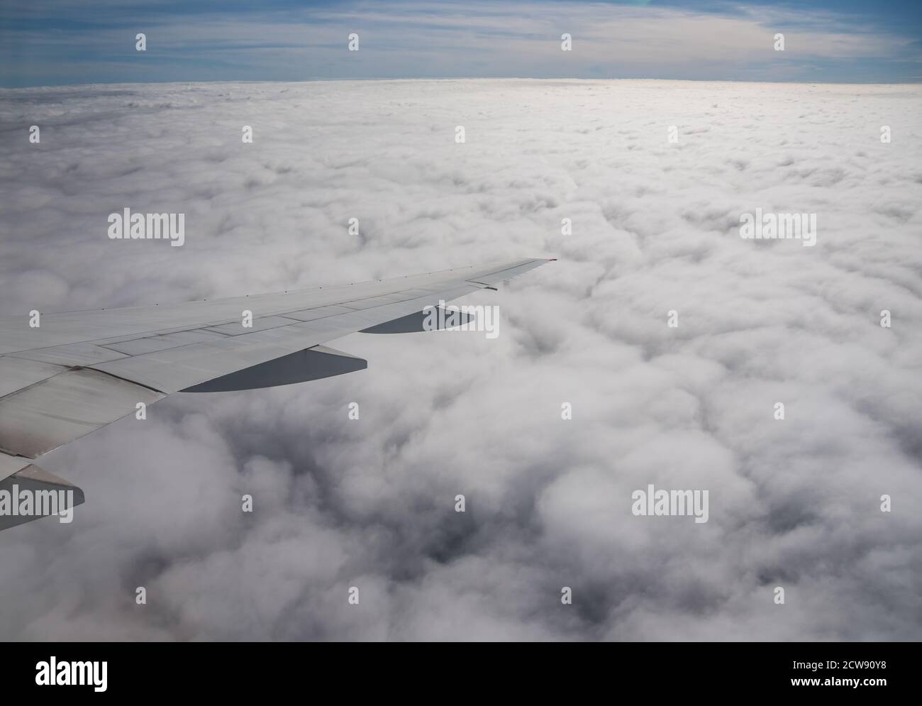 Aerial View from an Airplane. Flying above Clouds at Sunrise Stock Photo
