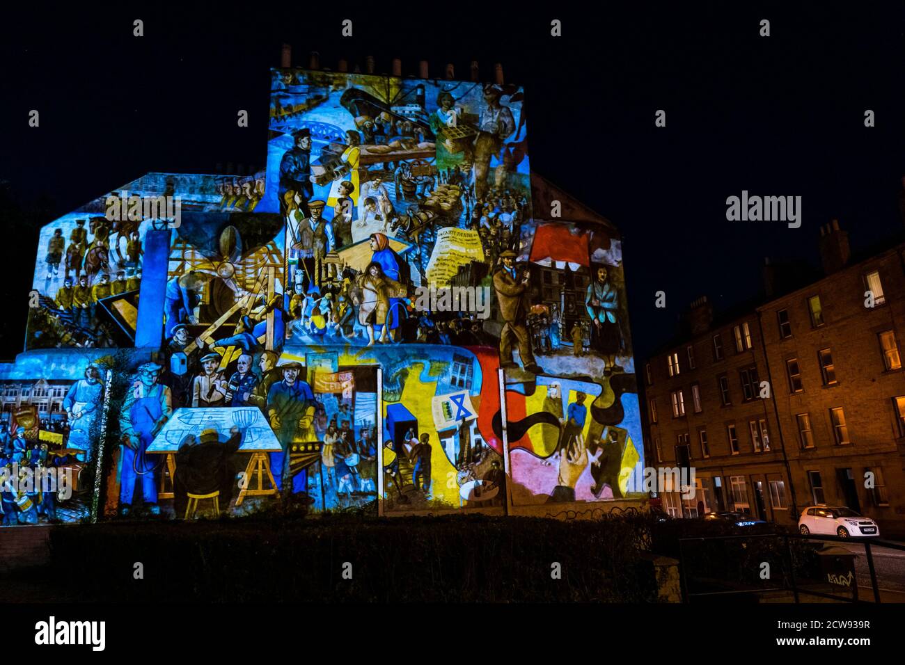 Leith, Edinburgh, Scotland, United Kingdom, 28th September 2020. Leith Lights Up: a Double Take Production lighting projection onto a local mural depicting Leith's social and industrial history by artists Tim Chalk and Paul Grime installed in 1986. The event runs until October 4th Stock Photo