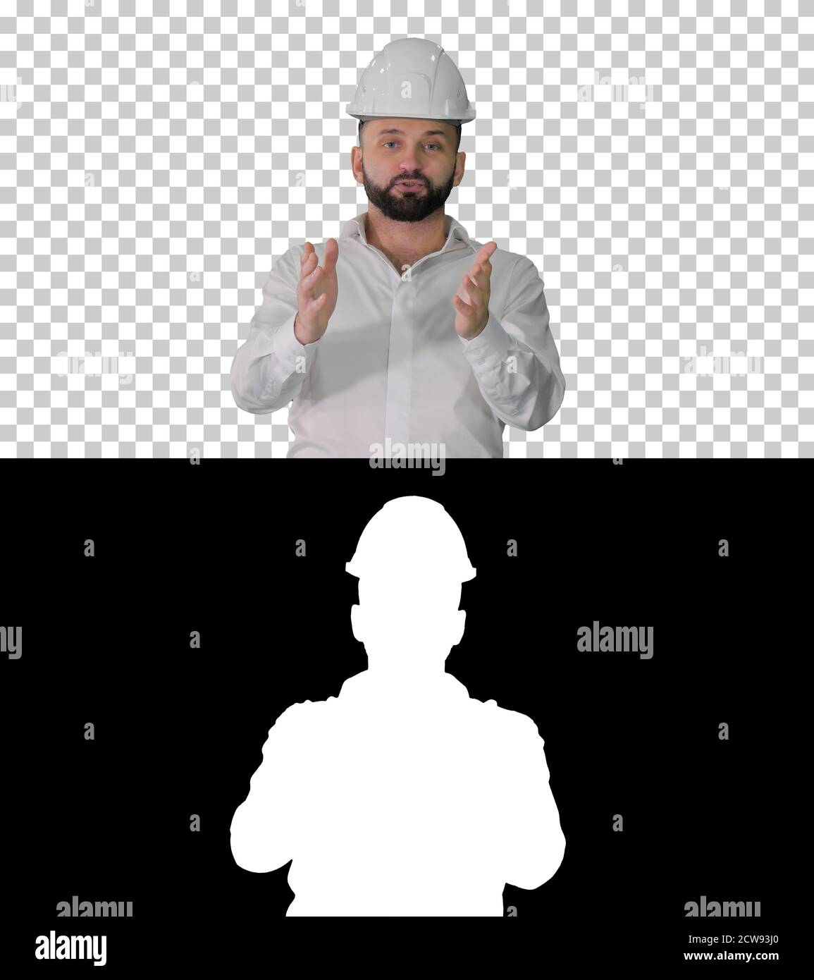 Engineer in a white helmet explaining something to camera, Alpha Stock Photo
