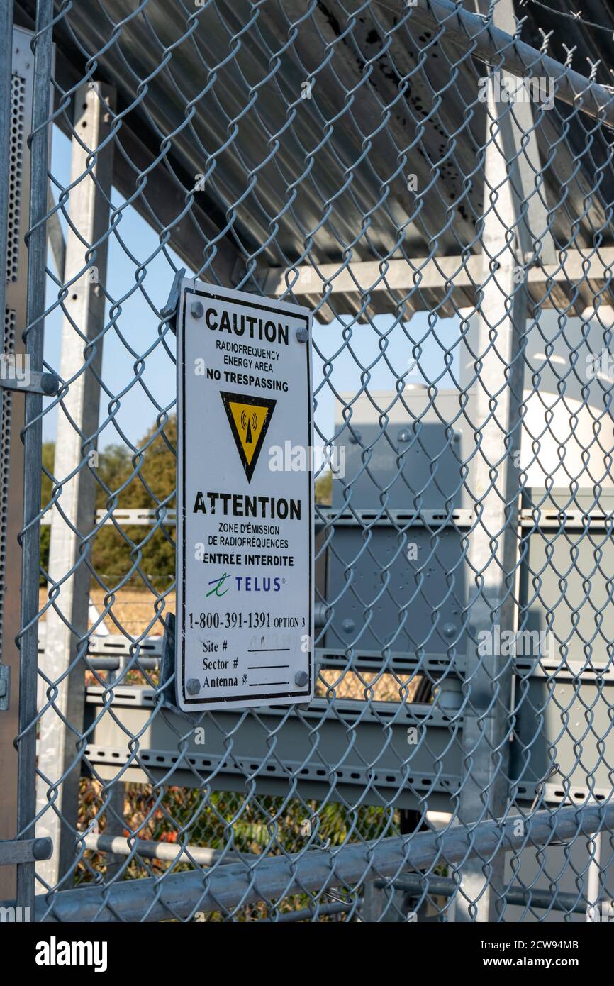 A no-tresspassing warning sign on a small fenced enclosure in Ottawa, Canada warns of a radio-frequency energy area around cell phone service equipmen Stock Photo