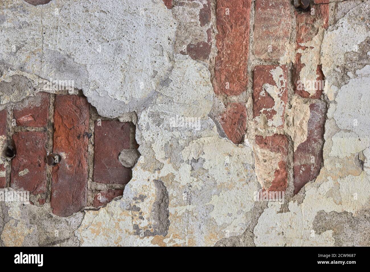 destroyed brick wall with fallen off plaster. Stock Photo