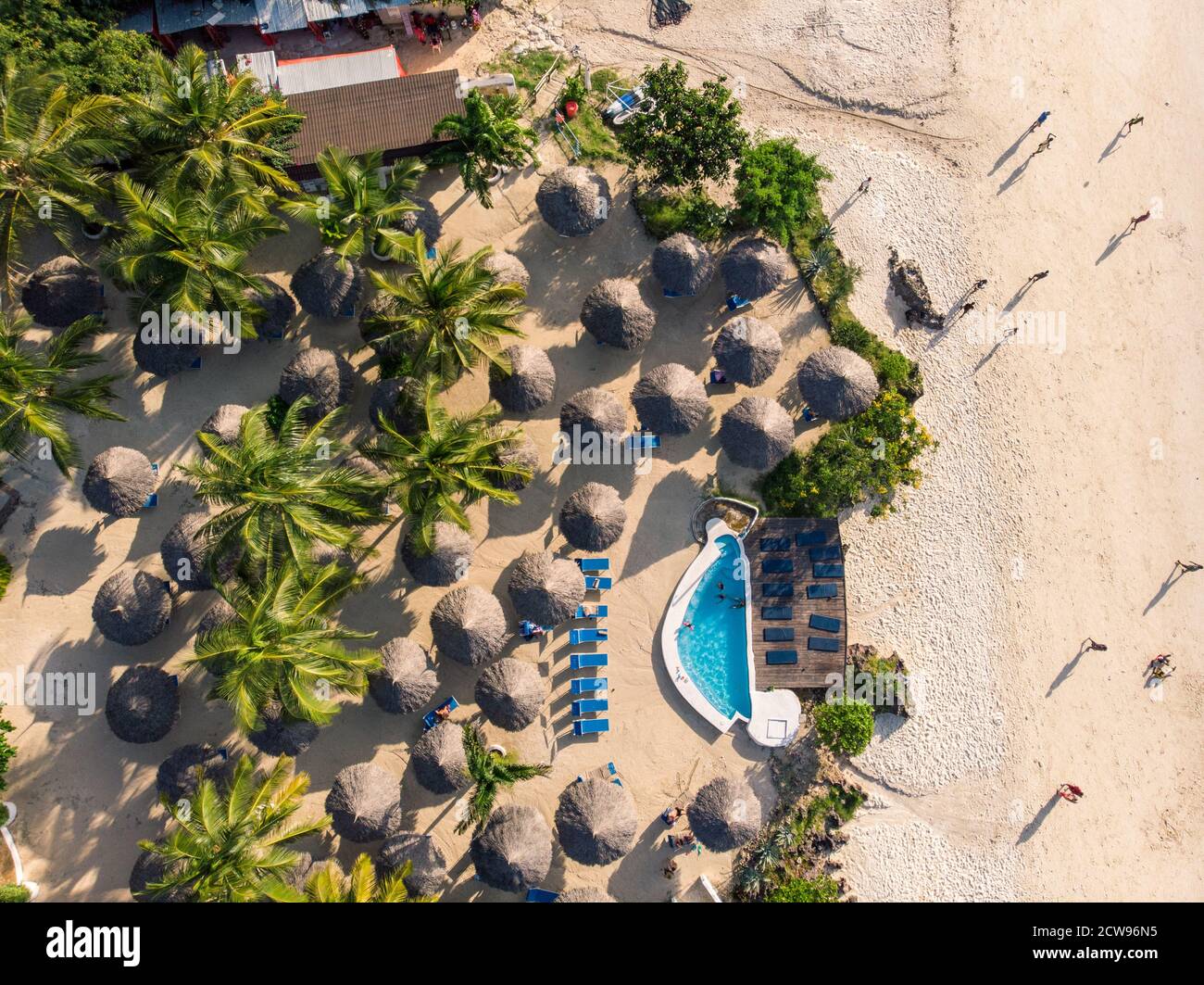 Top Aerial view of Thatched roofed beach umbrellas of luxury ocean view resort at the beautiful white sand ocean coast in Nungwi at Zanzibar island Stock Photo
