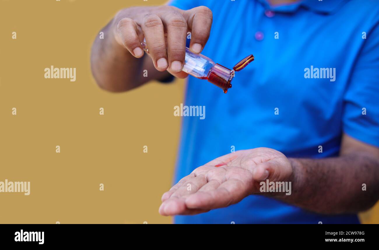 Man pouring massage aroma oil on hands Stock Photo