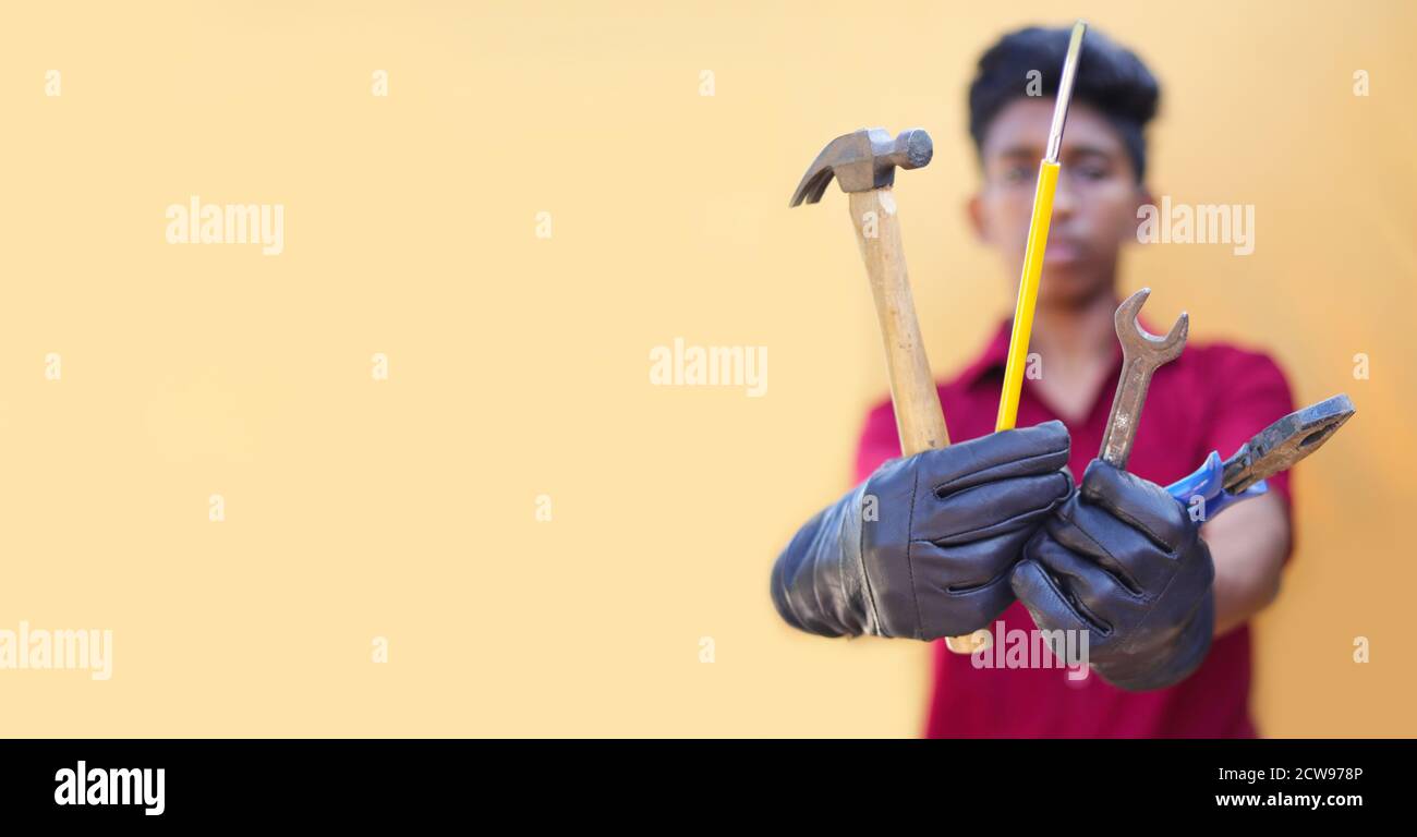 Handsome auto mechanic with tools on yellow backgrounds Stock Photo