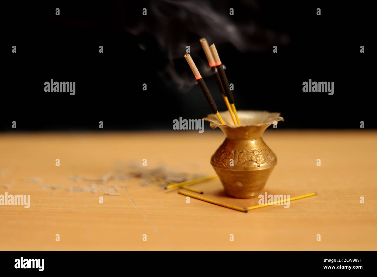 Burning incense sticks, reed diffuser with black detail label on a