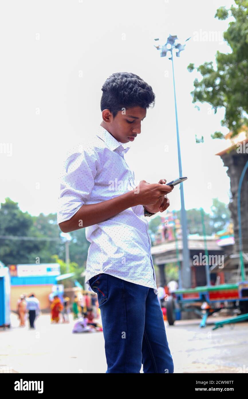 Young man using smartphone against background Hindu temples Stock Photo