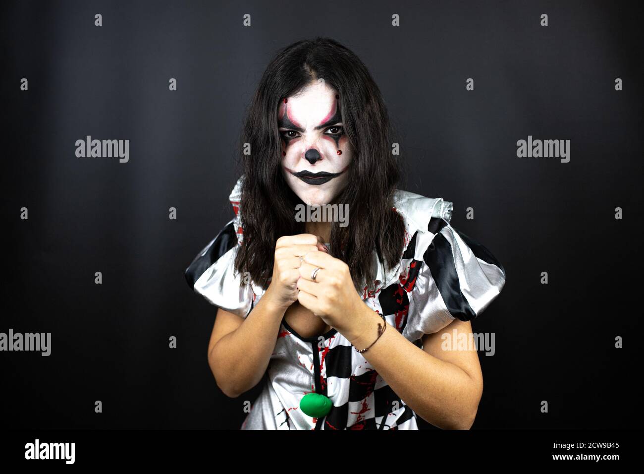 woman in a halloween clown costume over isolated black background
