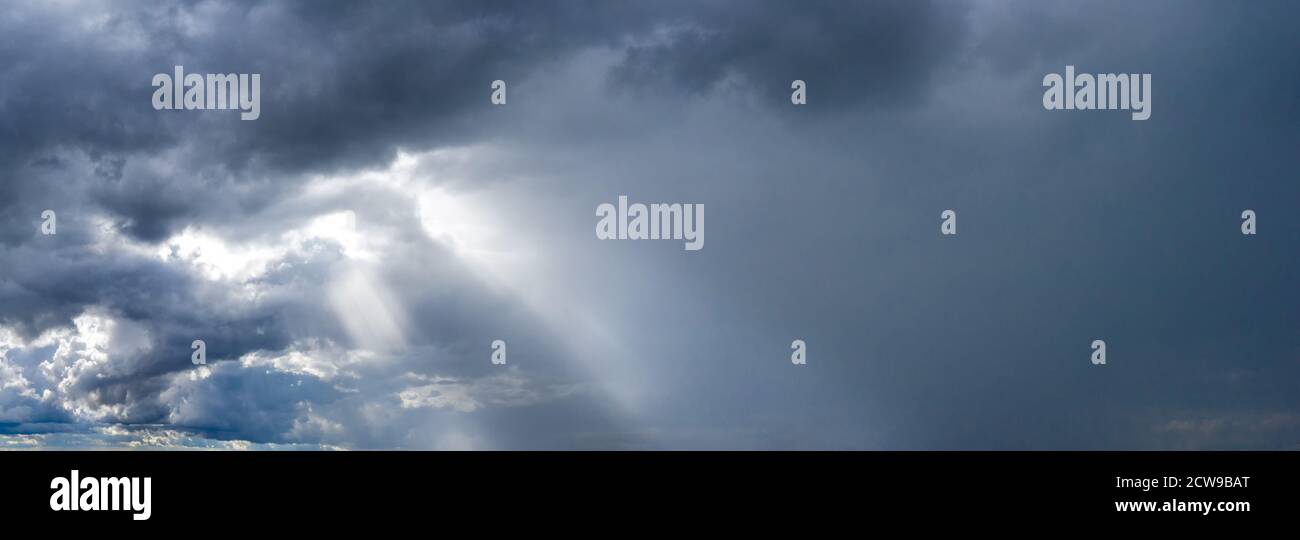 The sun's rays break through the dark stormy sky Stock Photo - Alamy