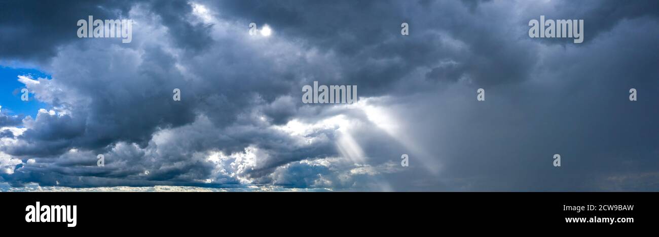 The sun's rays break through the dark stormy sky Stock Photo - Alamy