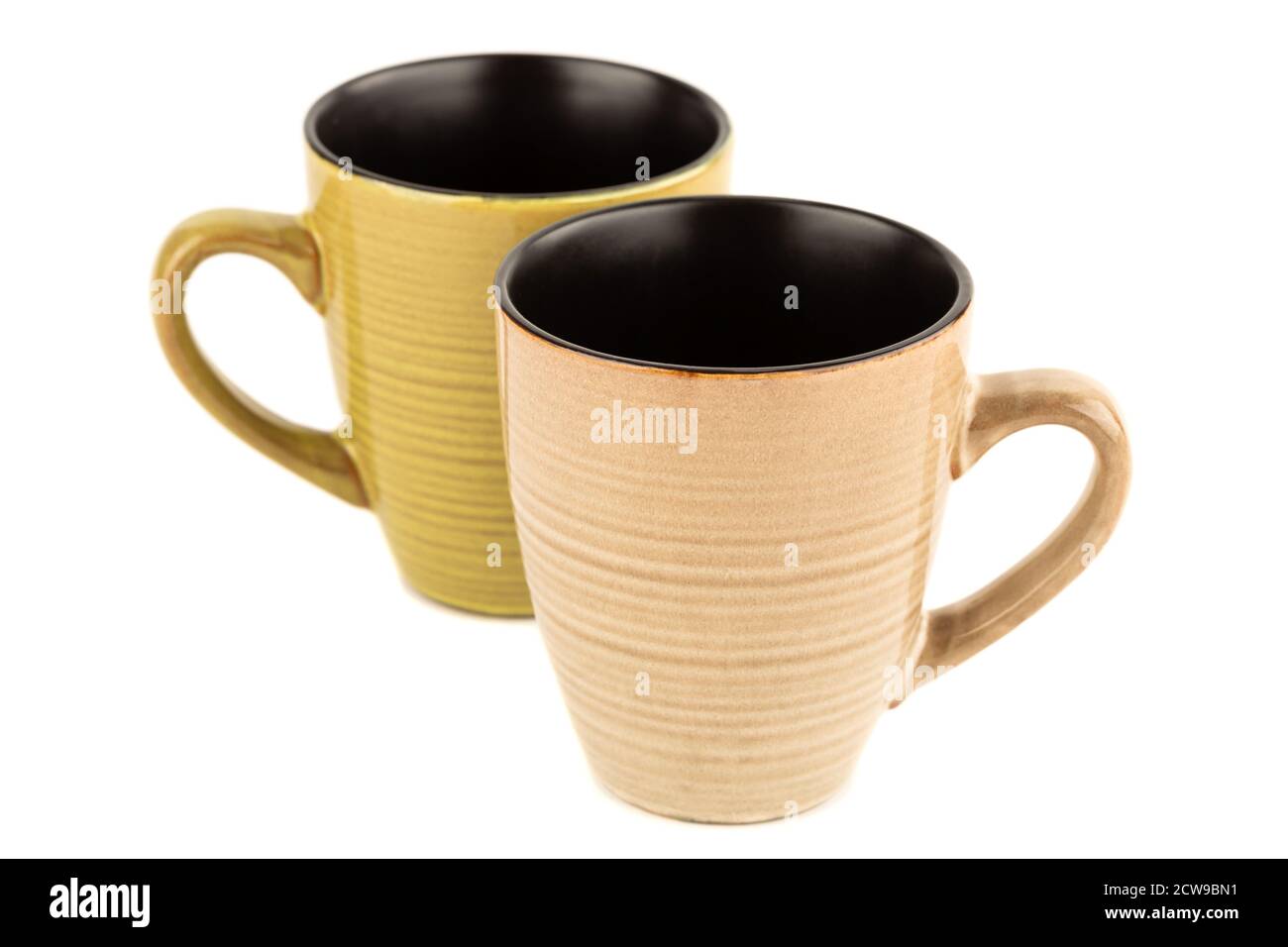 Two ceramic cups isolated on blue background. Stock Photo