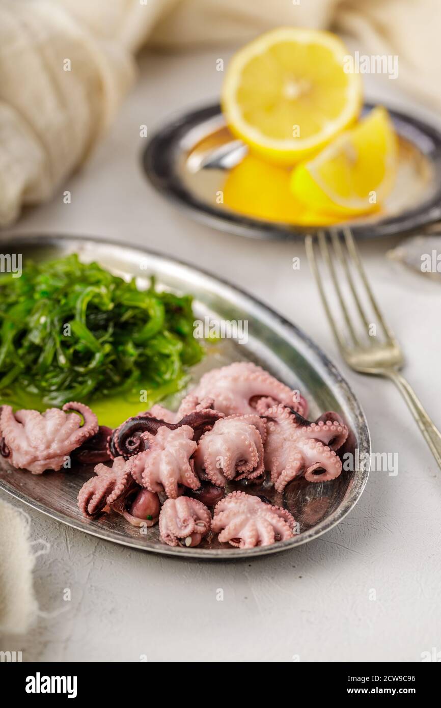 Traditional asian food. Delicious boiled octopus with fresh wakame salad. Stock Photo