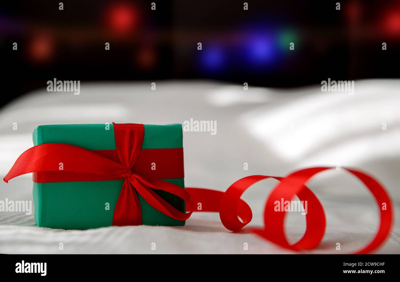 Green Christmas box with red ribbon on white background Stock Photo - Alamy