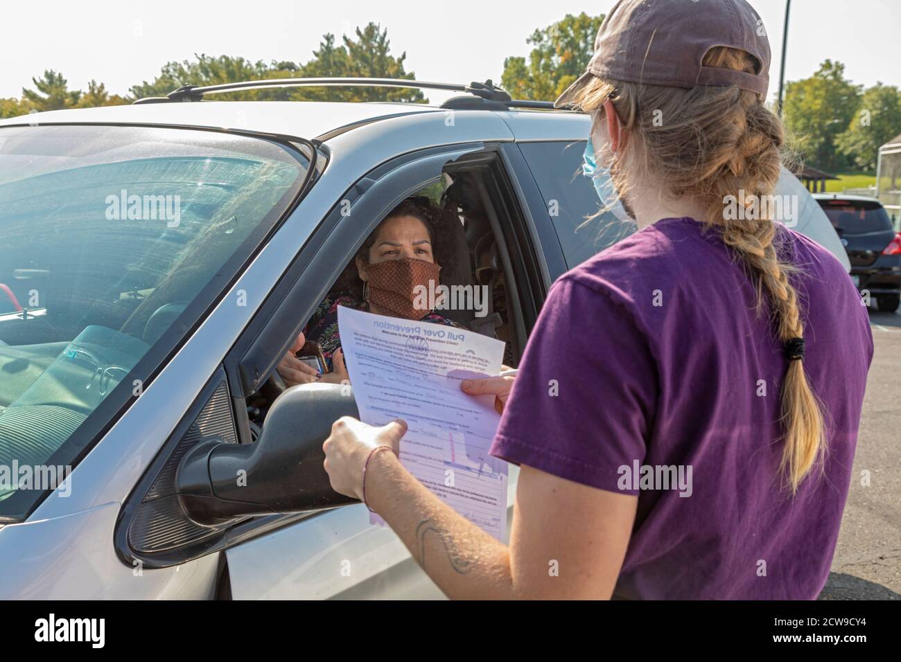 Ypsilanti, Michigan - A woman explained what repairs her car needs as professional and amateur auto mechanics made free repairs at a Pull Over Prevent Stock Photo