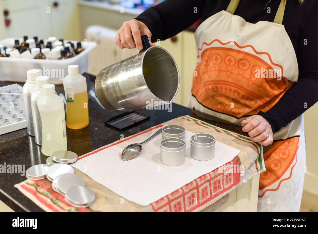 Creative occupation of candle making showing the pouring of liquid wax