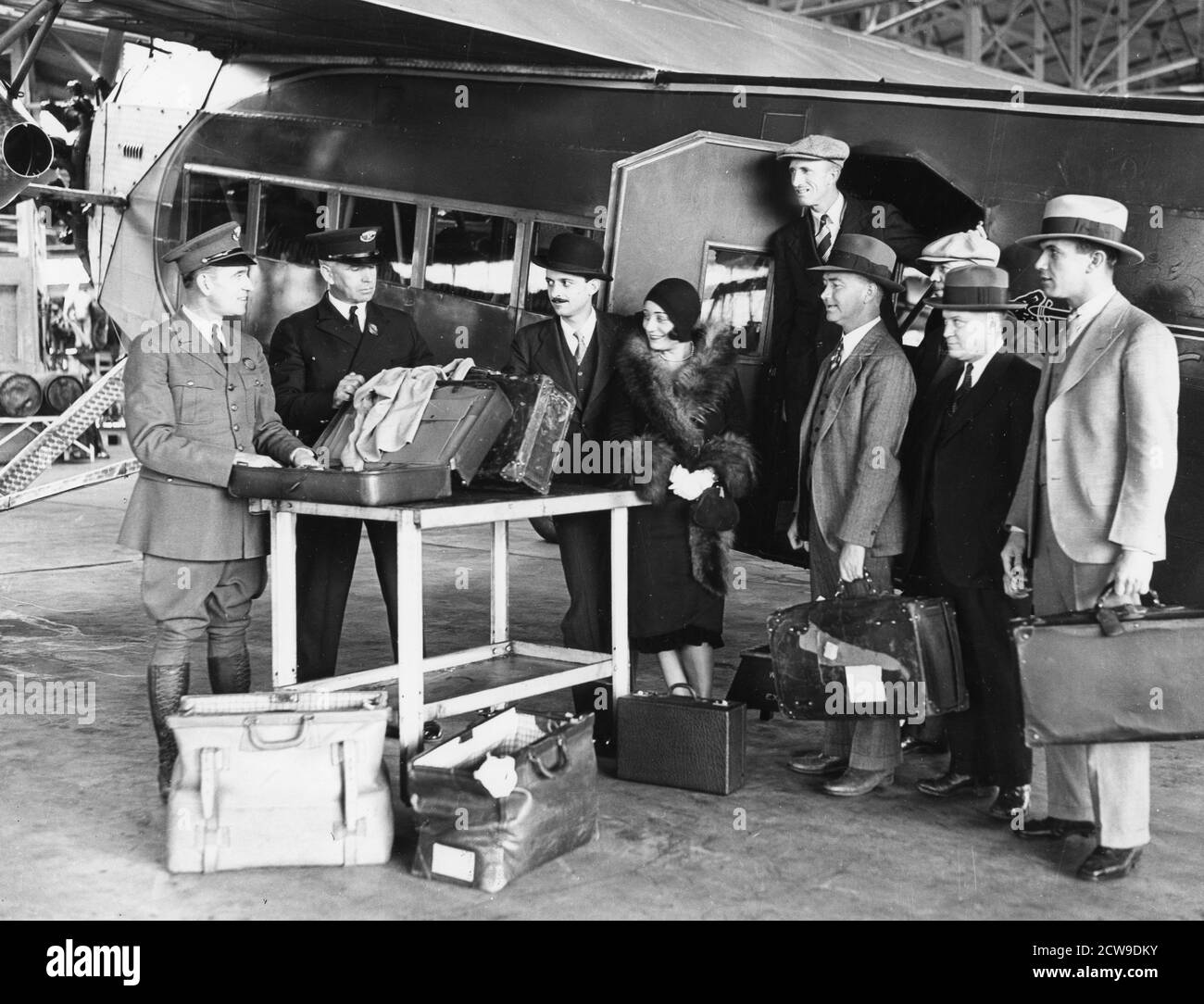 Customs inspectors check the baggage of passengers as they deplane from a Fokker F-10 operated by Western Air Express, Alhambra, CA, 1929. (Photo by Western Air Express/PhotoQuest/RBM Vintage Images) Stock Photo