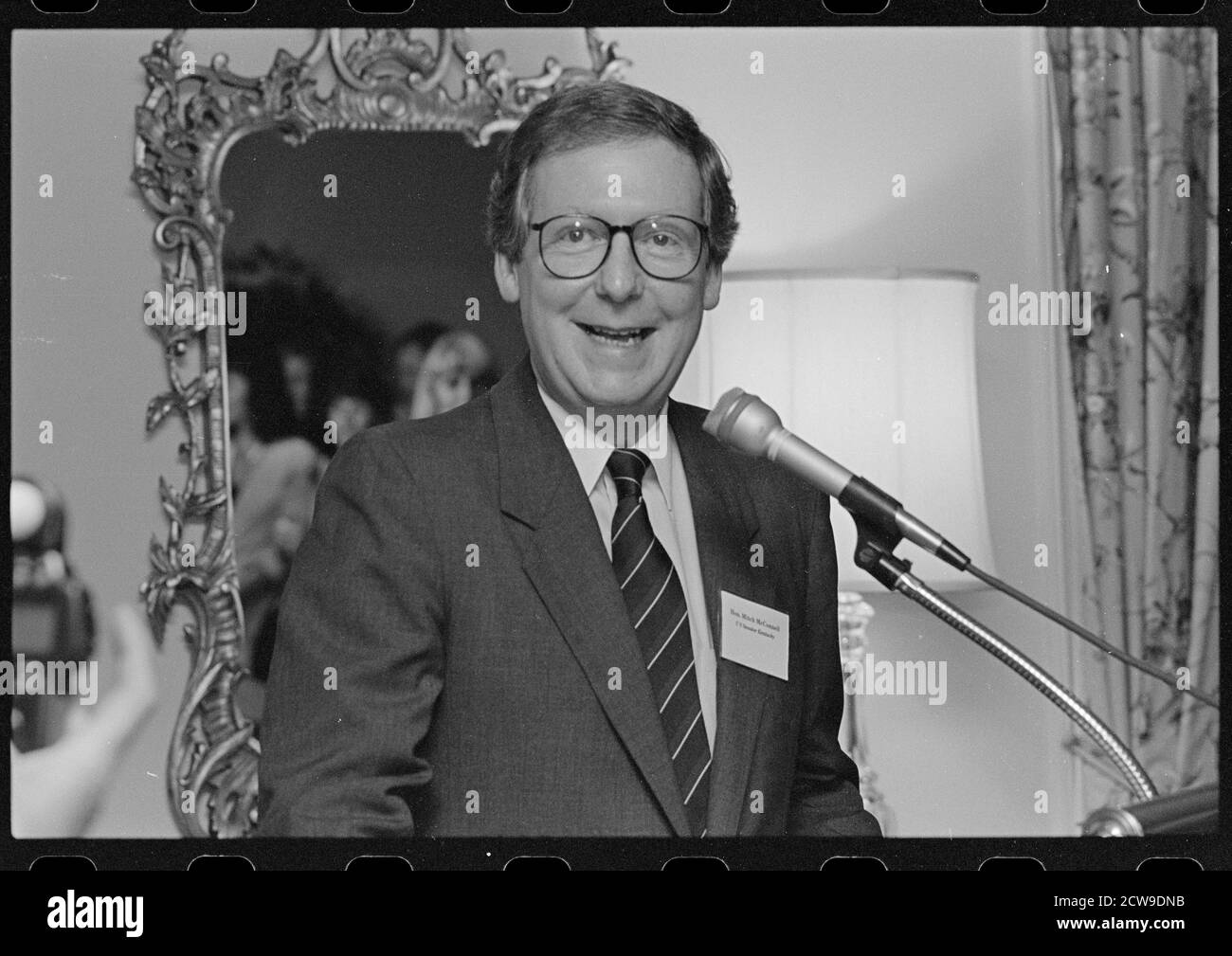 Smiling Senator Mitch McConnell, head-and-shoulders portrait, facing front, speaking at microphone at a gathering of Republican Party women candidates, Washington, DC, 6/1992. (Photo by Laura Patterson/CQ Roll Call Collection/RBM Vintage Images) Stock Photo