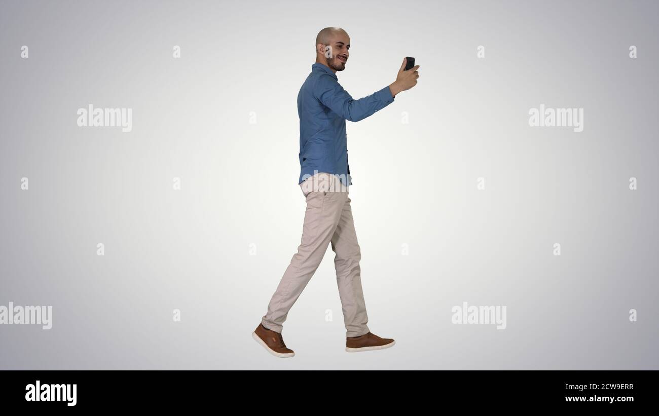 Happy smiling handsome young man making selfie while walking on Stock Photo