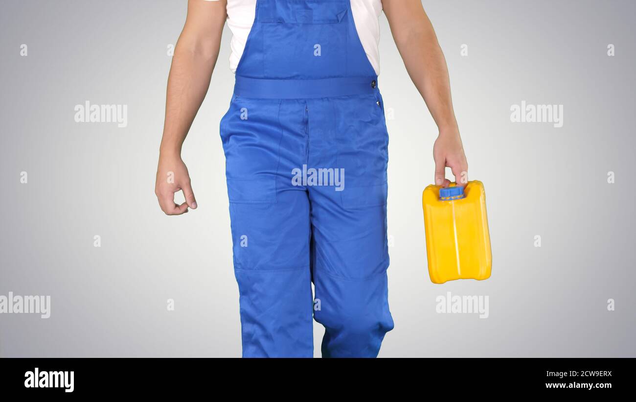 Construction worker in hard hat holding plastic canister and wal Stock Photo