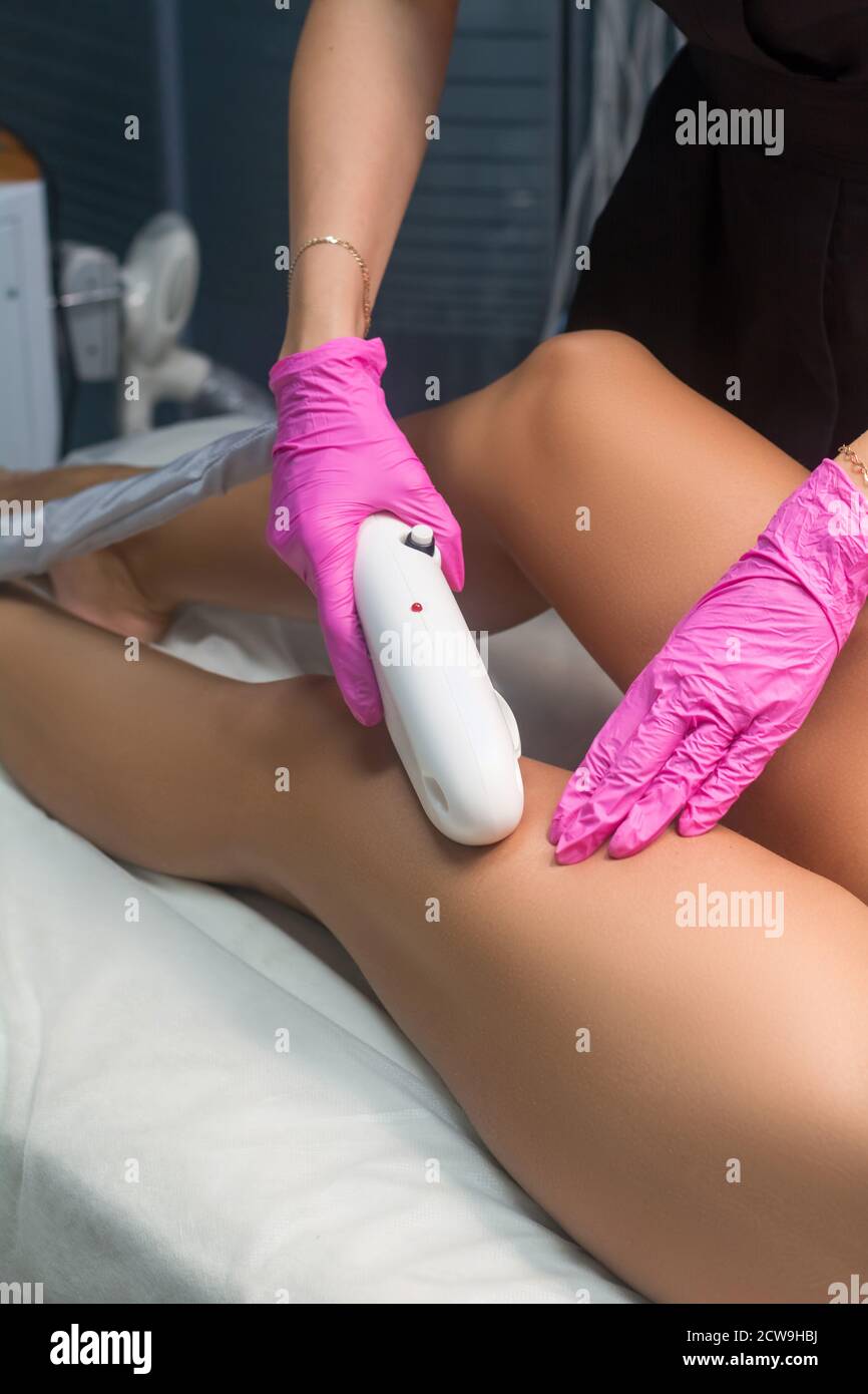 Beautician makes Elos epilation. Leg hair removal procedure Stock Photo