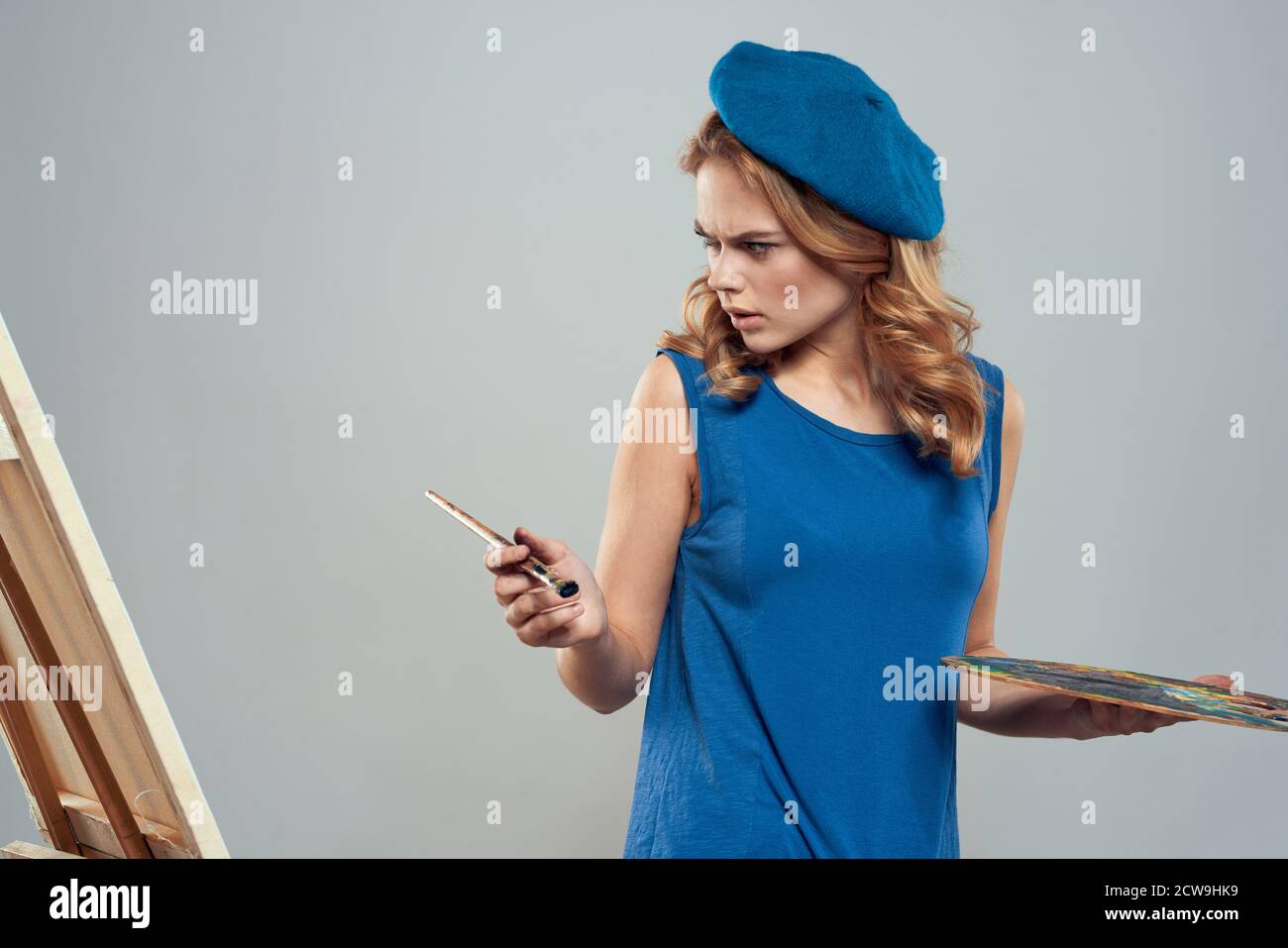 woman artist blue beret palette drawing on easel art creativity light ...