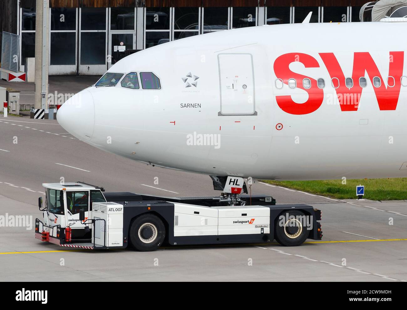 Goldhofer AST-1X tug pushing back Swiss Airlines Airbus A330 airplane. Towbarless towing vehicle operation at Zurick Kloten Airport. Aicraft tractor. Stock Photo