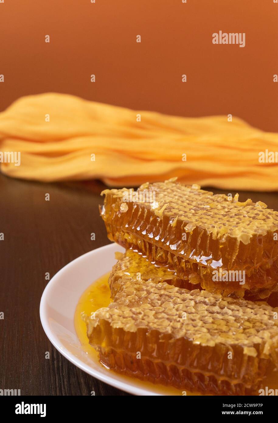 Honeycombs in white plate on the wooden table. Natural organic bee product. Healthy lifestyle. Copy space for your text. Close-up photo. Stock Photo