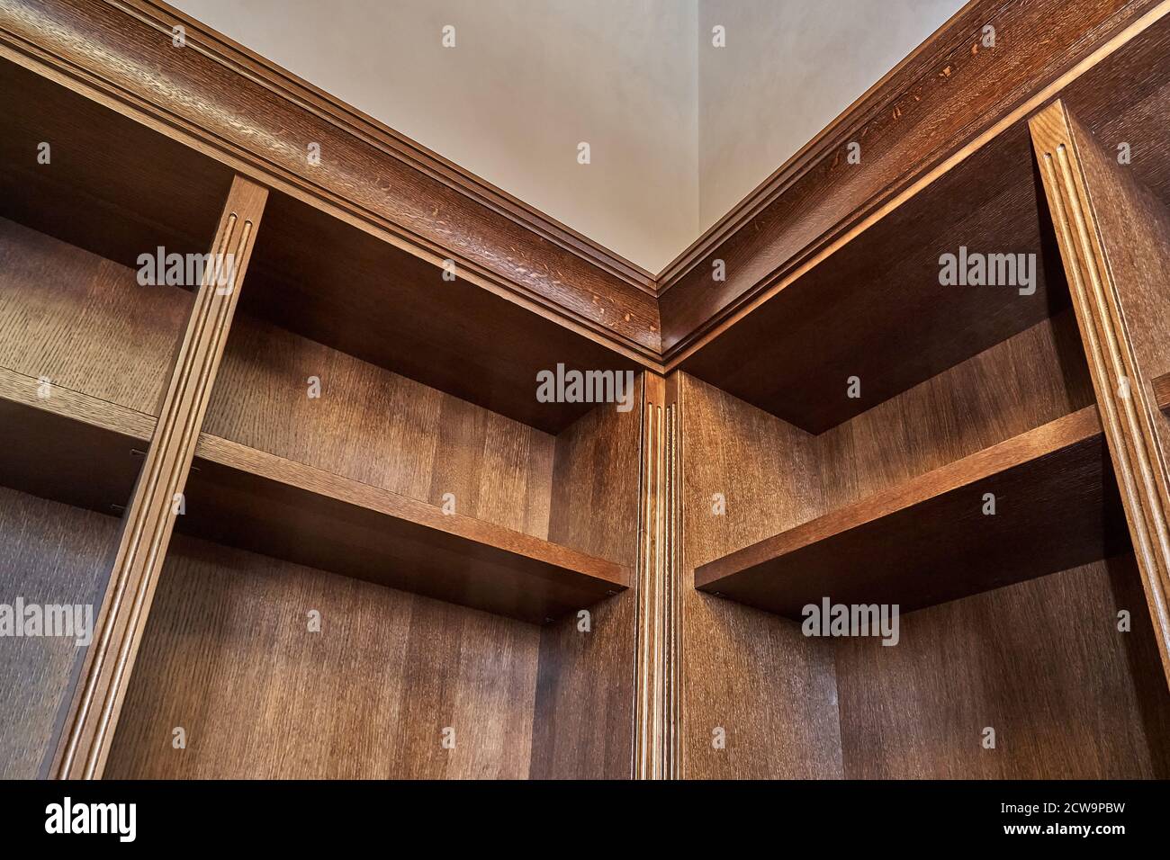 Home library. Detail of antique wooden bookcase with empty shelves placed in home library in house Stock Photo