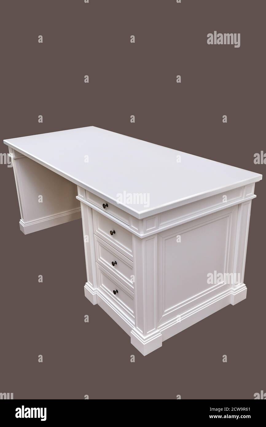 White wooden classic writing desk with drawers isolated against brown background Stock Photo