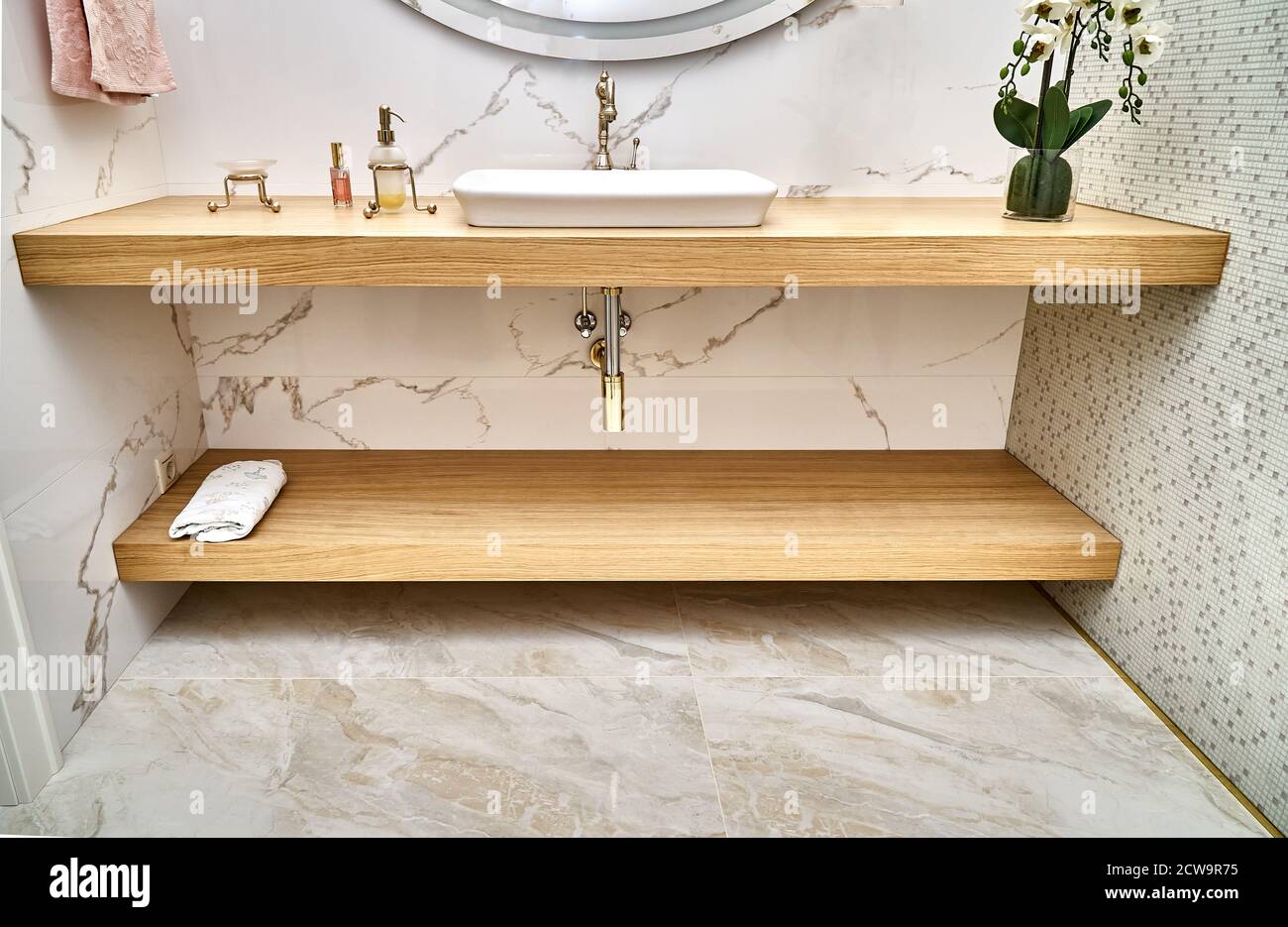 Floating wooden basin countertops with white ceramic sink and golden