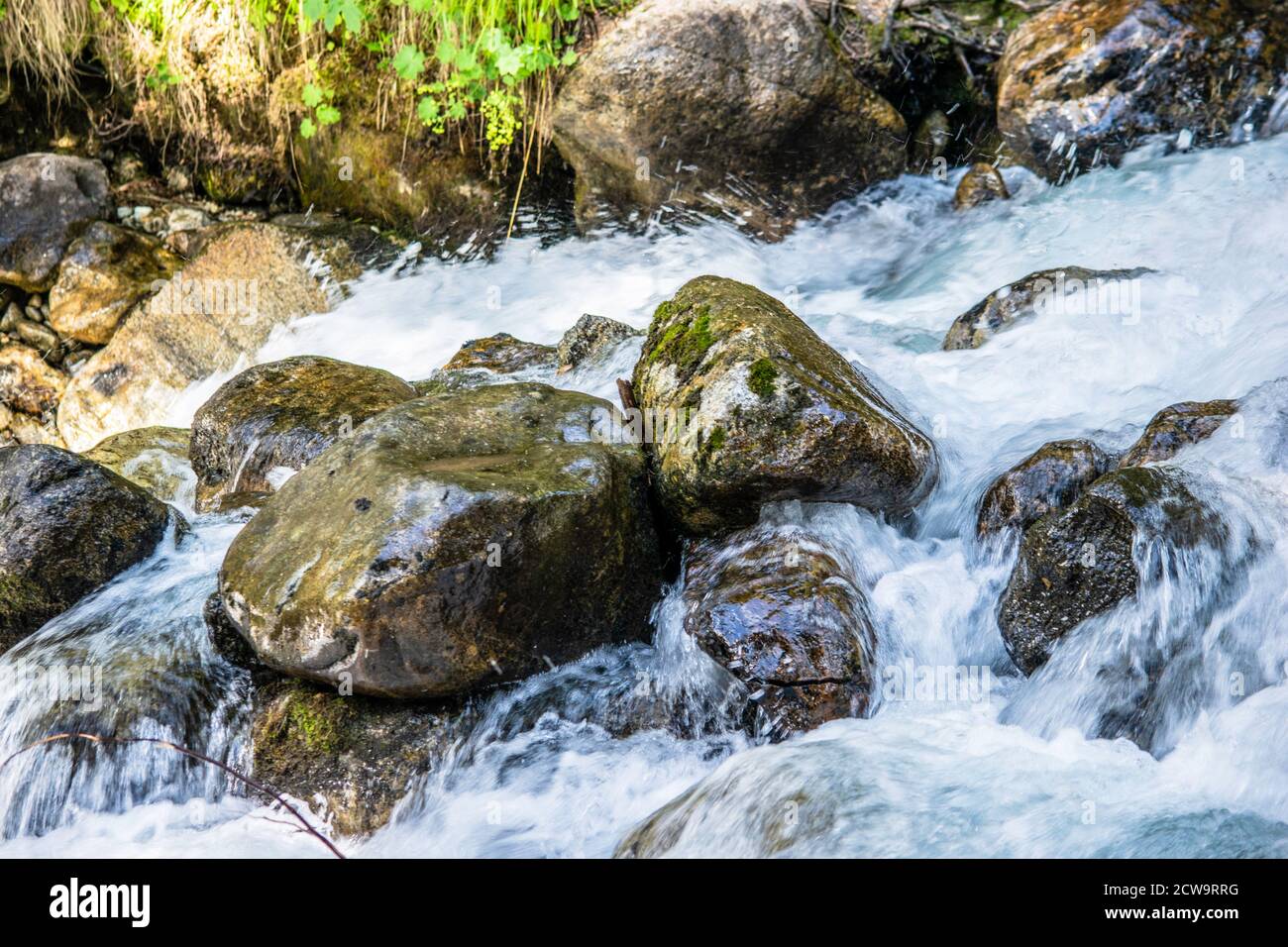 the water of a stormy mountain river flowing among stones and boulders ...