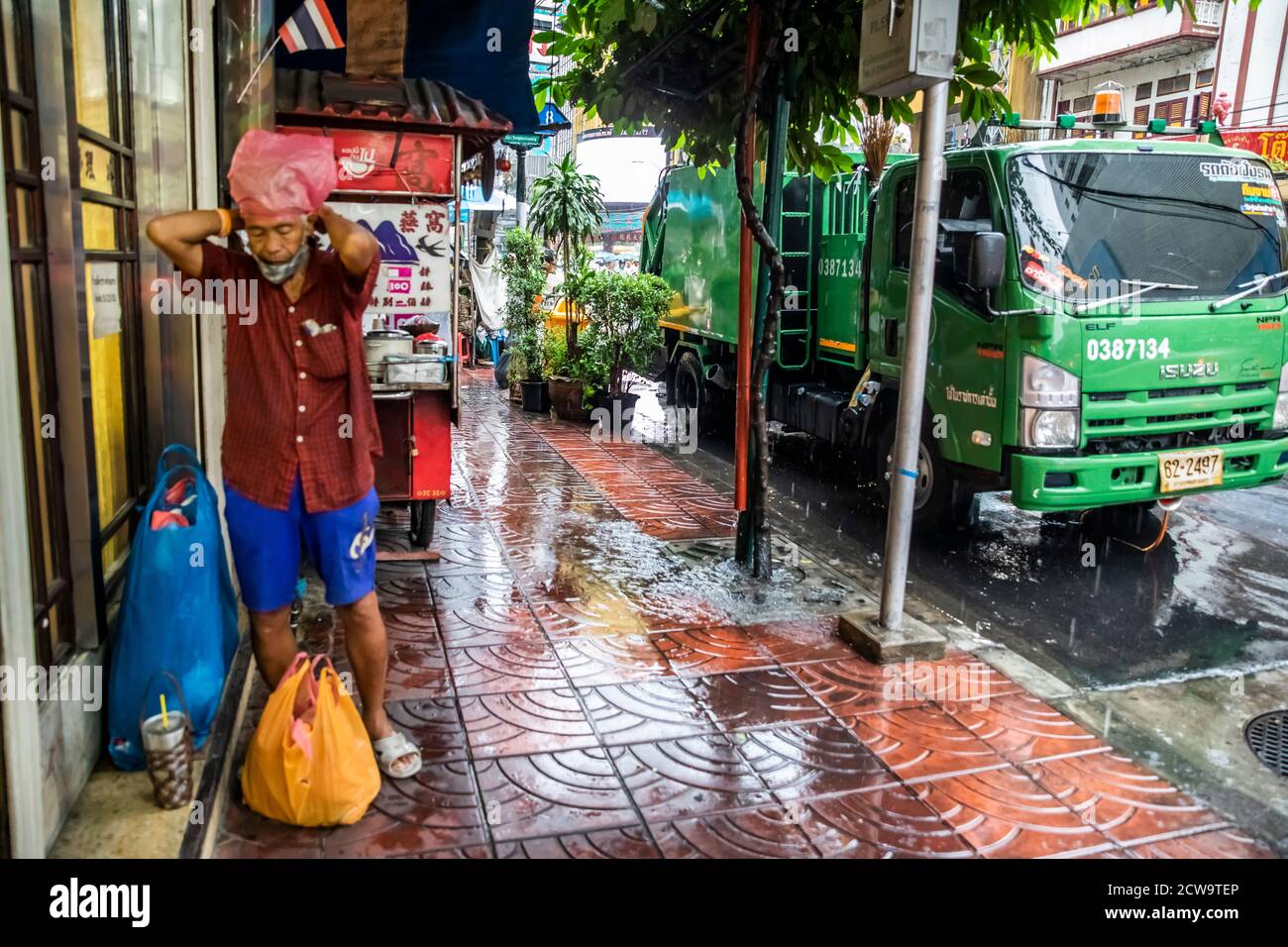 A man wraps a pink plastic shopping bag over his head before he heads