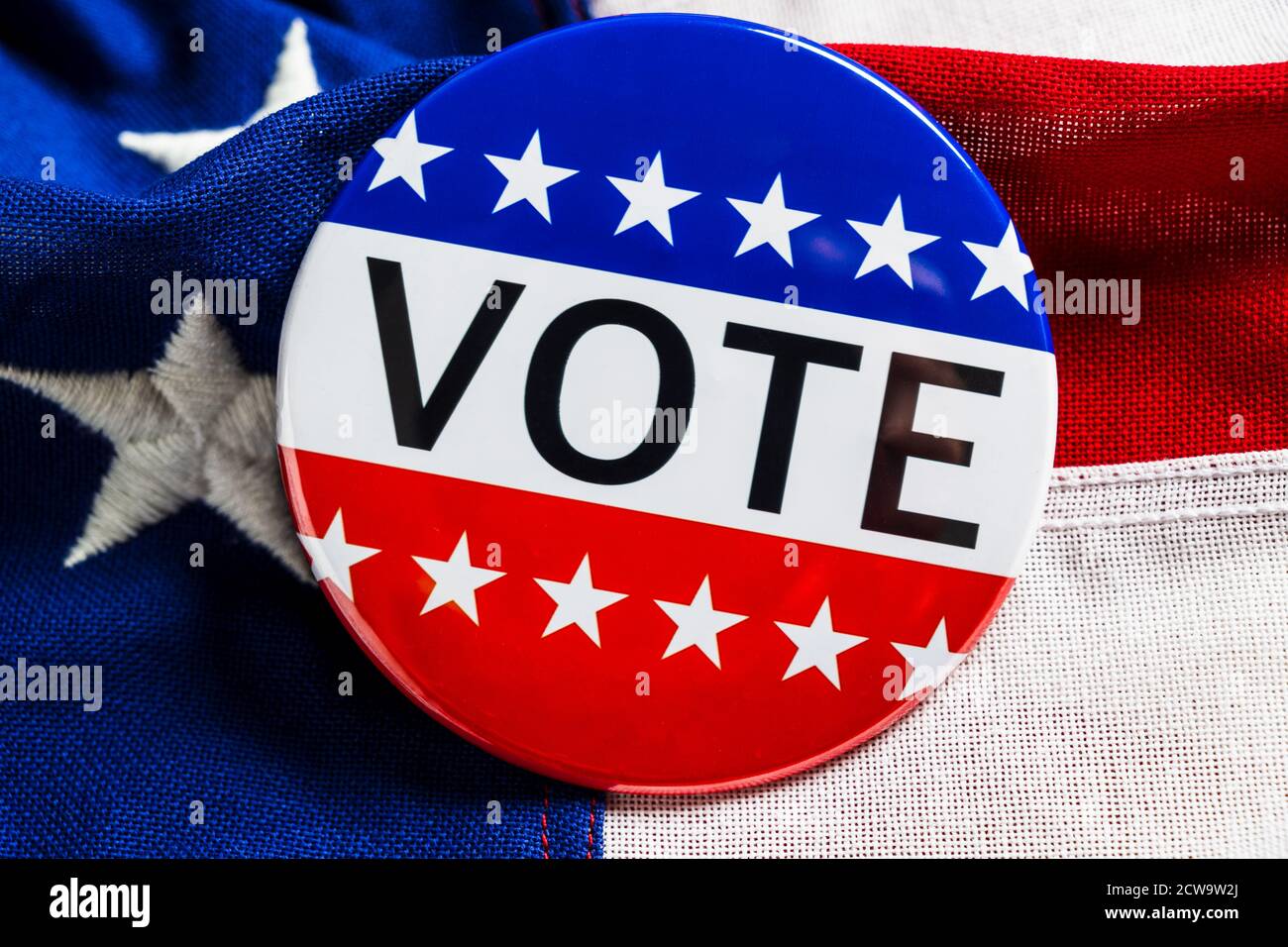 A red, white and blue VOTE button on an American flag Stock Photo