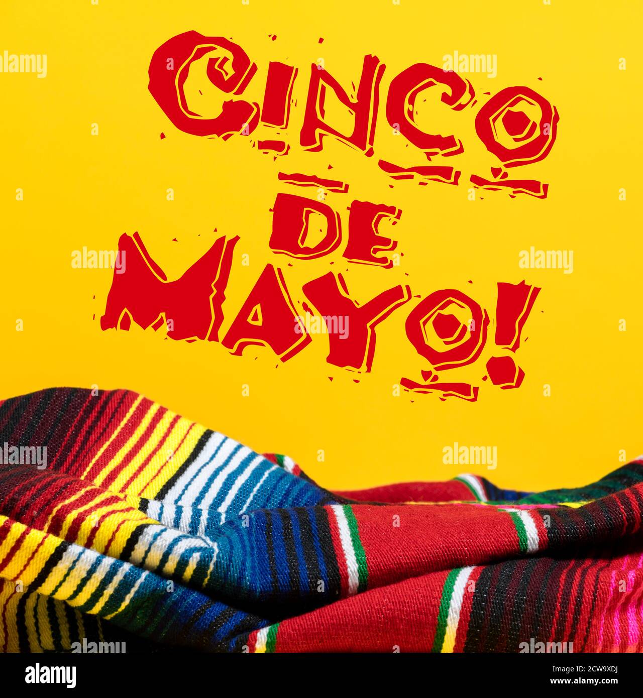 Mexican Serape blanket on yellow background with Cinco de Mayo.  Stock Photo