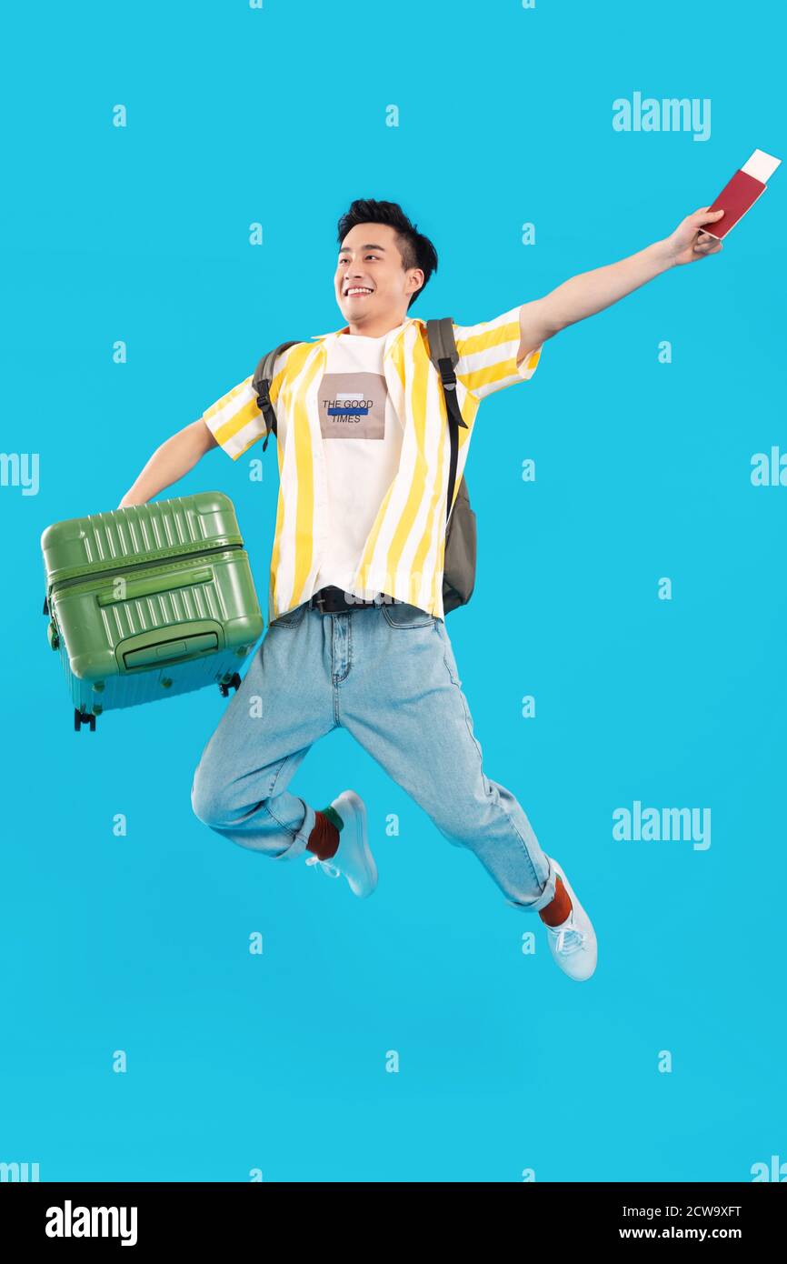 Carrying a suitcase bouncing young man Stock Photo