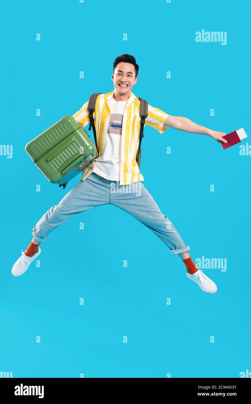Holding the suitcase bouncing young man Stock Photo